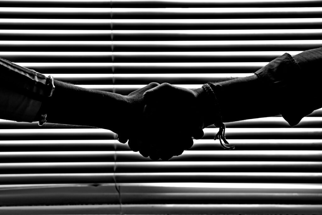 Strategic Partnerships and Collaborative Silhouette of two people shaking hands symbolizing partnership and trust.